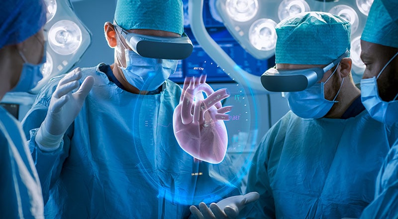 surgeons in surgical gear and vr headsets looking a 3d visualization of a heart